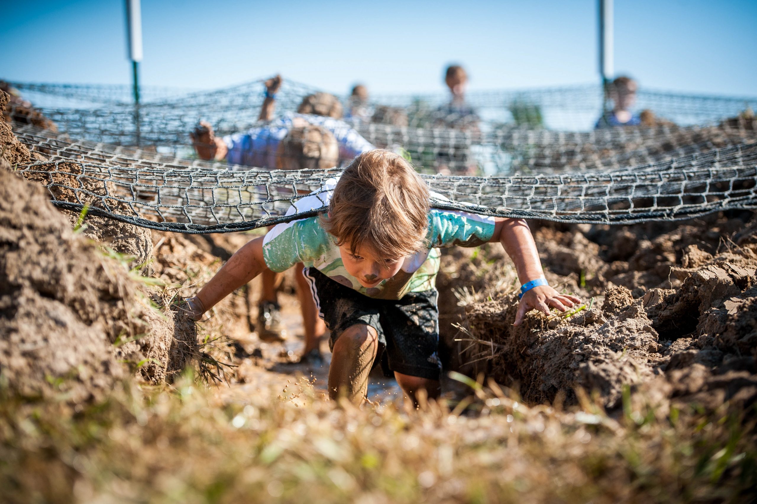 Splat: Young boy navigating net obstacle.