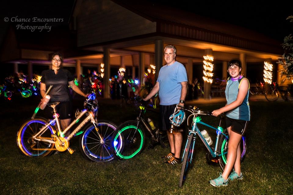 Nighttime picture of people preparing to ride bicycles