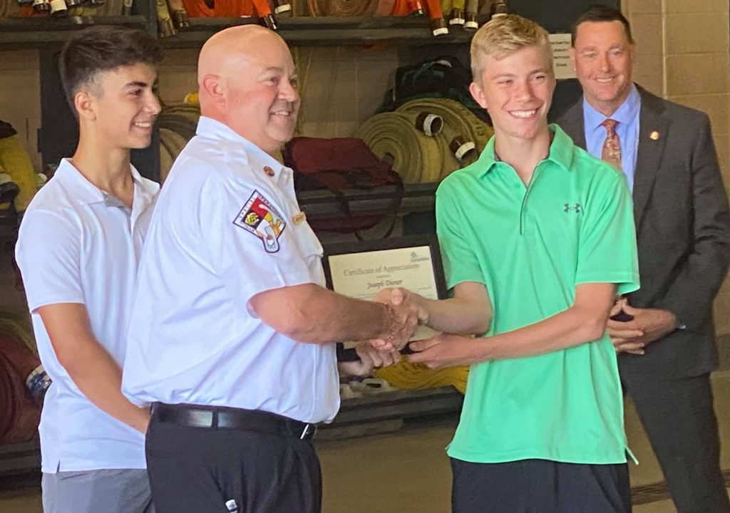 Dominic Viet and Joseph Diener receiving the Citizen Lifesaving Award from Fire Chief Andy Woody.