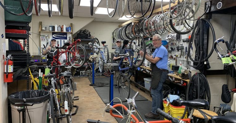 Three bike mechanics work on bicycles at the Co-op.