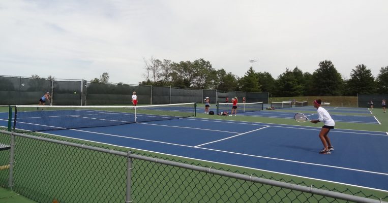 Firing off a serve at Cosmo Bethel Tennis Courts.