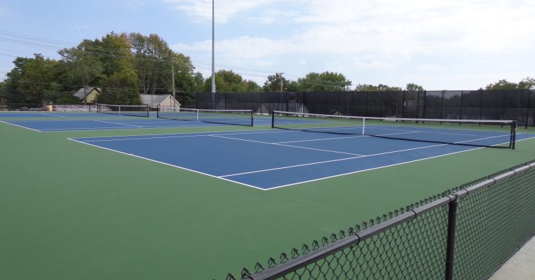 Hickman High School tennis courts with fence in foreground.