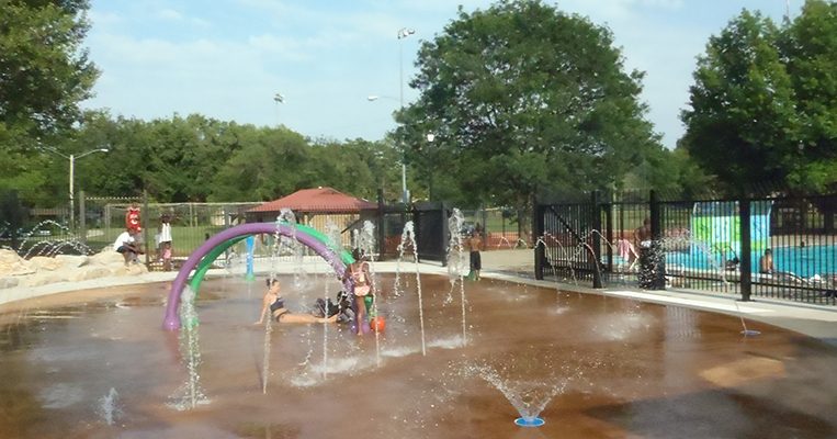 Bathers relaxing in the middle of the Douglass Family Aquatic Center Spraygrounds.