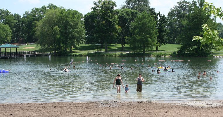 People wading in the water at Stephens Lake Beach
